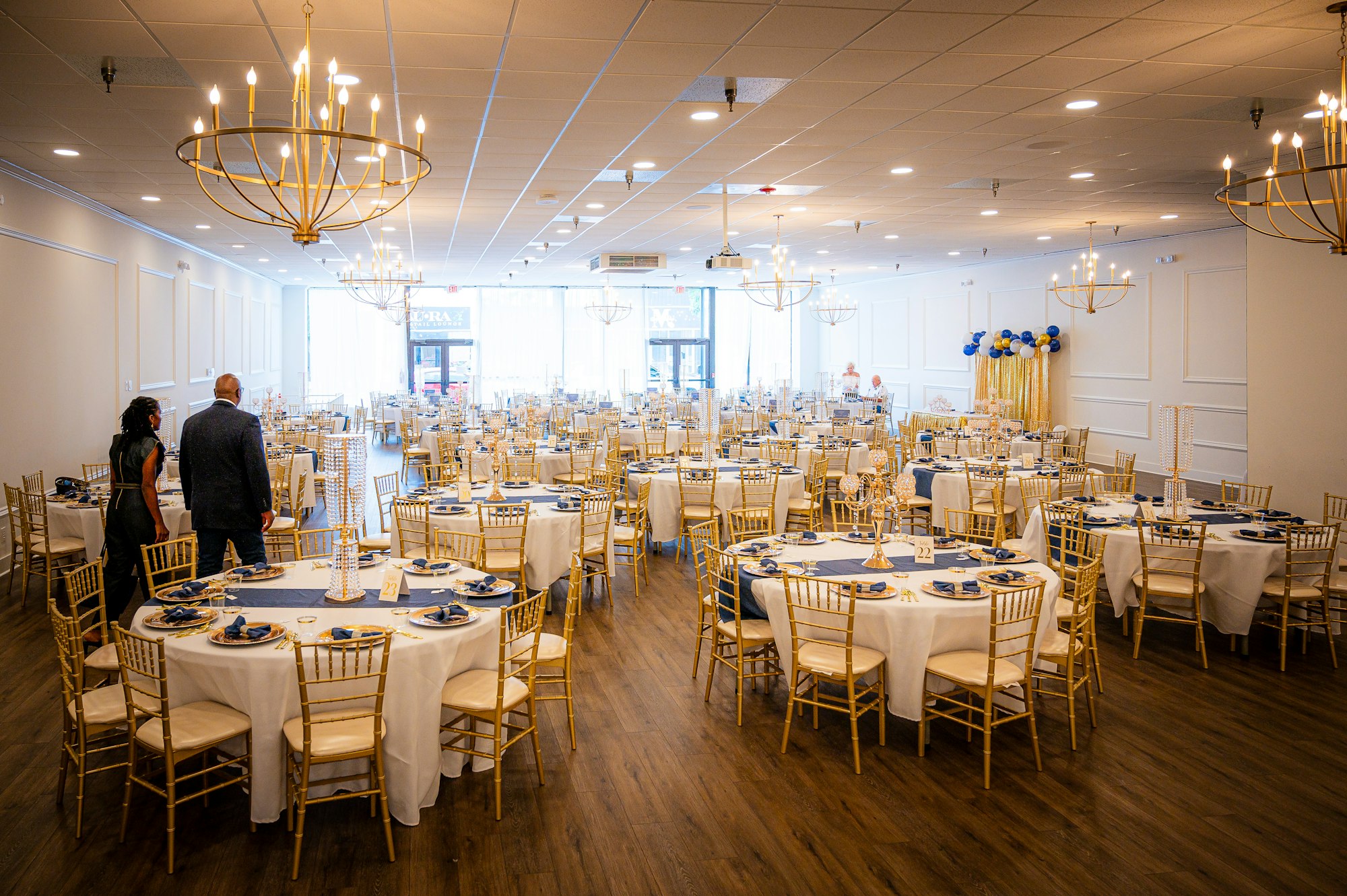 An empty reception room set with round tables and chairs before the guests arrive